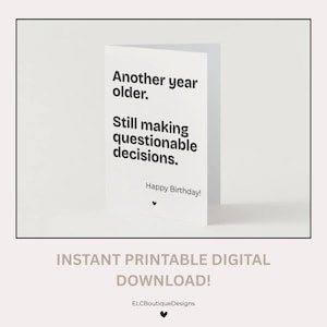 Op de afbeelding: Een witte wenskaart met zwarte tekst die luidt: Another year older. Still making questionable decisions. Happy Birthday! Een klein zwart hartpictogram bevindt zich onder de tekst. De kaart wordt aangeboden als digitale download.