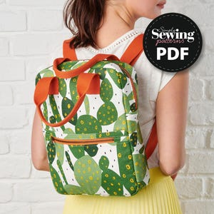 May include: A backpack with a cactus print in shades of green and yellow on a white background. The backpack has orange straps and a zipper. The image includes a circular logo that says "Simply Sewing patterns PDF".