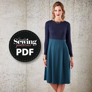 May include: A navy blue and teal dress with long sleeves and a fitted bodice. The dress has a flared skirt and a round neckline. The dress is photographed against a textured gray background. The text "Simply Sewing patterns PDF" is in a circle on the left side of the image.