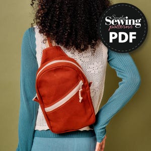 May include: A rust-colored sling backpack with a white zipper and strap detail. The bag is worn over the shoulder. The image includes a circular logo that says "Simply Sewing patterns PDF".