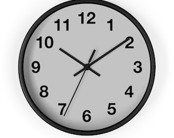 May include: A round wall clock with a black frame and a light gray face. Black numerals mark the hours, and black hands indicate the time. The clock is set to approximately 10:10.