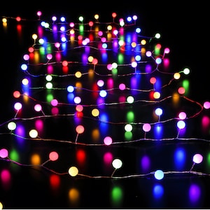 Pode incluir: Fio de luzes com pequenas lâmpadas LED redondas multicoloridas em um fio de cobre fino. As luzes são em tons de vermelho, verde, azul, amarelo e rosa, criando uma exibição vibrante e festiva. Perfeito para decoração.