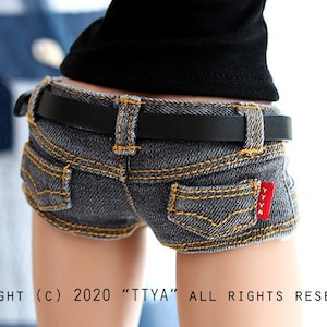 May include: A pair of denim shorts with a black belt and a gold buckle. The shorts have a red label with the text "TTYA" on the back pocket.