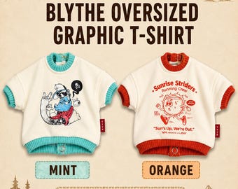 May include: Two oversized graphic t-shirts with ribbed collars and hems. The left shirt is cream with mint trim and a cartoon character graphic. The right shirt is cream with orange trim and a sun character graphic with text Sunrise Striders.