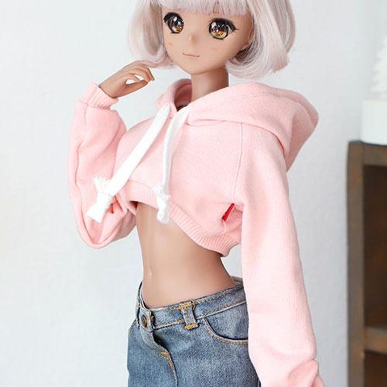 Puede incluir: Una sudadera con capucha rosa recortada con un cord&oacute;n blanco y una capucha. La sudadera est&aacute; hecha de un tejido suave y c&oacute;modo y tiene un corte holgado.