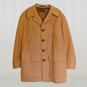 May include: A tan wool coat with a large collar and four front pockets. The coat has five brown buttons down the front.