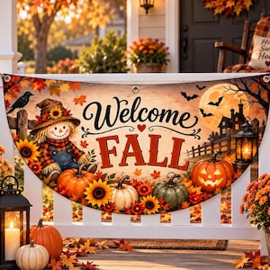 以下が含まれることがあります： Welcome FALLの文字、かかし、ひまわり、カボチャ、お化け屋敷、コウモリが描かれた半円形のバナー。秋の葉、満月、ランタンがデザインされており、白いポーチの手すりに掛けるための金属製のハトメが付いています。