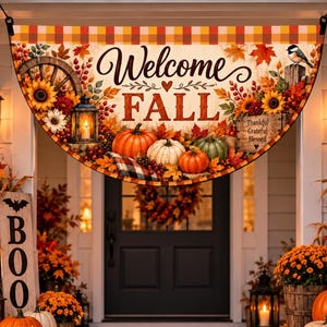 Op de afbeelding: Een halfronde stoffen banner met de tekst Welcome FALL, versierd met pompoenen, zonnebloemen, herfstbladeren, een lantaarn en een vogel. Het ontwerp bevat een geruite rand en een houten bordje met de woorden Thankful Grateful Blessed.
