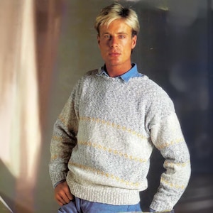 May include: A gray and white striped sweater with a yellow stripe detail. The sweater has a crew neck and long sleeves.