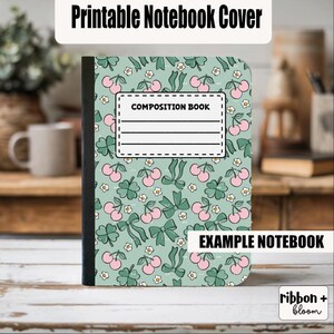 Può includere: Un quaderno di composizione con una copertina verde chiaro con un motivo di ciliegie rosa, fiocchi verdi e fiori bianchi. Il quaderno ha un'etichetta bianca con la scritta "COMPOSITION BOOK" e il testo "EXAMPLE NOTEBOOK".