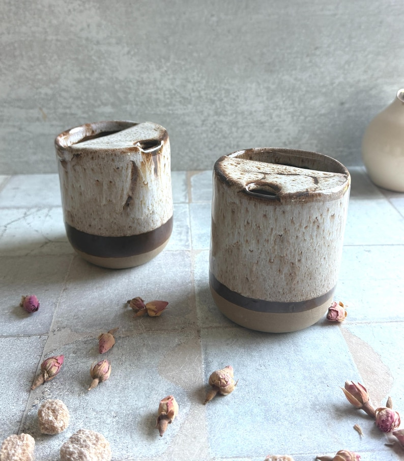 Detailed view of rustic glaze on pottery travel mug, showing melted marshmallow-inspired speckles and brown accents