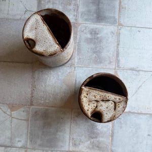 Top view of handcrafted ceramic travel mug in toasted marshmallow style, showing sip hole and interior glaze, 16 oz rustic cup for camping or coffee lovers gifts
