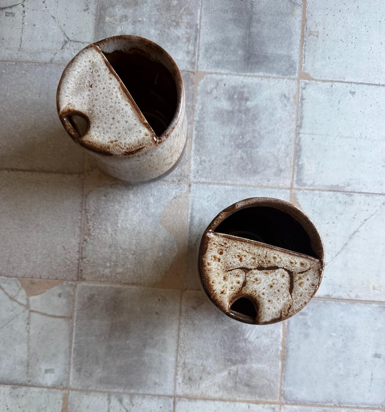 Top view of handcrafted ceramic travel mug in toasted marshmallow style, showing sip hole and interior glaze, 16 oz rustic cup for camping or coffee lovers gifts
