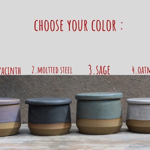 Peut inclure: Quatre pots en c&eacute;ramique avec couvercles, chacun d'une couleur diff&eacute;rente : jacinthe, acier mouchet&eacute;, sauge et avoine. Les pots ont un design bicolore, avec une base marron clair et un dessus color&eacute;. Le texte "CHOISISSEZ VOTRE COULEUR" est au-dessus des pots.