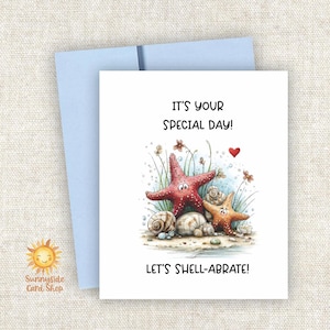 May include: A greeting card with a light blue envelope. The card features two cartoon starfish, one red and one orange, with seashells and the text "IT'S YOUR SPECIAL DAY! LET'S SHELL-ABRATE!"