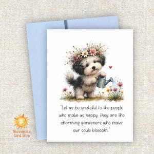 May include: A greeting card featuring a fluffy black and white puppy wearing a flower crown and holding a blue watering can. The text reads: Let us be grateful to the people who make us happy: they are the charming gardeners who make our souls blossom.