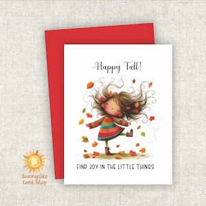 May include: A white greeting card with a red envelope featuring an illustration of a child with long brown hair wearing a striped sweater, dancing amidst falling autumn leaves. The text reads Happy Fall! and FIND JOY IN THE LITTLE THINGS.