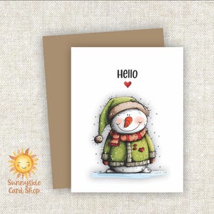 May include: A greeting card featuring a cartoon snowman wearing a green hat, scarf, and jacket. The word "Hello" is above the snowman, with a red heart. The card is on a brown envelope, with the "Sunnyside Card Shop" logo.
