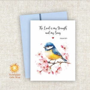 May include: Greeting card with a watercolor illustration of a blue and yellow bird perched on a flowering branch. The card has the text "The Lord is my Strength and my Song" and a light blue envelope.