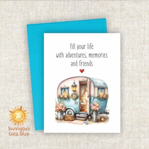 May include: Greeting card with a watercolor illustration of a vintage camper in shades of blue and pink, with the text "Fill your life with adventures, memories and friends." A turquoise envelope is behind the card. The Sunnyside Card Shop logo is in the lower left corner.