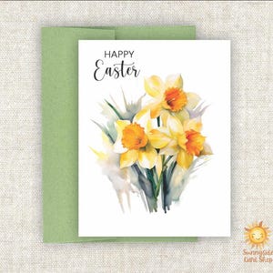 May include: A white card with the text "Happy Easter" in black script. The card features a watercolor painting of three yellow daffodils with orange centers.