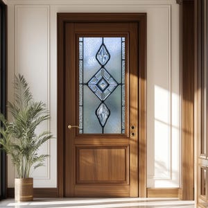 May include: A wooden front door with a decorative glass panel featuring a geometric design. The door is a warm brown color and has a brass handle. The glass panel has a diamond and teardrop pattern.