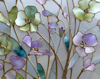 May include: A stained glass panel featuring a floral design with purple, green, and blue flowers. The flowers have a pearlescent finish and are outlined with gold-colored metal. The background is a light, translucent color.