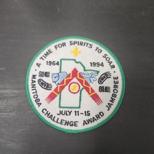 May include: A circular patch with a green border and the text "A TIME FOR SPIRITS TO SOAR." The patch features a map outline, the years 1964 and 1994, and the words "MANITOBA CHALLENGE AWARD JAMBOREE JULY 11-15."