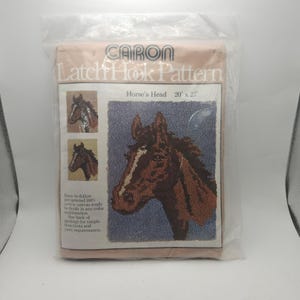 May include: A white ceramic mug with a black handle and the text "But First, Coffee" in a bold, black font. The mug is set against a blurred background, suggesting a cozy setting.