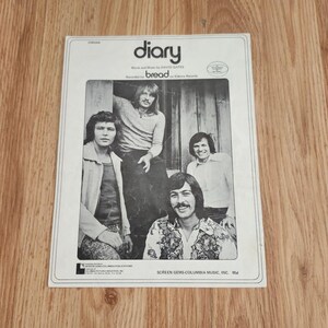May include: Sheet music for the song "Diary" by Bread. The cover features a black and white photograph of the band members. The text "diary" is in a bold, stylized font at the top, with the band's name below.