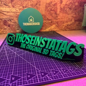 May include: A green and black 3D printed sign that reads "Those Insta Tags The Original 3D Tags!"