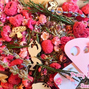Könnte beinhalten: Ein rosa-weißer Pilz aus Holz mit einem rosa-weißen Holz-Einhorn, rosa-weißen Holzblumen und rosa getrockneten Früchten. Der Text "Pretty Prairie Soul" steht auf dem Pilz.