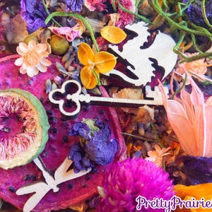 May include: A colorful mix of dried flowers, fruits, and wooden decorations. The mix includes dried dragon fruit, figs, lavender, and a wooden key. The text "Pretty Prairie Soul" is visible in the bottom right corner of the image.