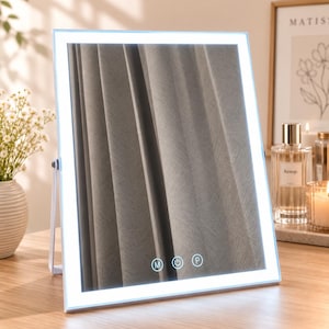 May include: A rectangular vanity mirror with a white frame and integrated LED lighting along the perimeter. The mirror features three touch-sensitive circular buttons at the bottom, labeled with the letters M, a power symbol, and P.