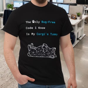 May include: A black t-shirt featuring the text "The Only Bug-Free Code I Know Is My Corgi's Tummy" in blue and white. A white geometric illustration of a corgi is below the text. The shirt is worn by a person.