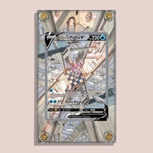May include: A framed Origin Forme Palkia V Pokémon card. The card features a detailed illustration of a futuristic cityscape with a central figure. The card is encased in a clear acrylic frame with gold-colored corner screws.
