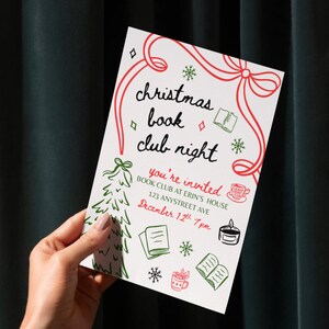 May include: A white invitation card for a Christmas book club night, held at Erin's House. The card features red and green illustrations of a Christmas tree, snowflakes, books, and a cup of coffee. The text reads "Christmas book club night" and "you're invited".