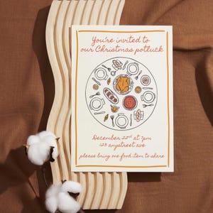 Könnte beinhalten: Cremefarbene Einladung mit orangefarbenem Rand und Text: "You're invited to our Christmas potluck." Eine kreisförmige Illustration eines Potluck-Essens befindet sich in der Mitte. Zusätzlicher Text: "December 22nd at 7pm, 123 anystreet ave, please bring one food item to share."