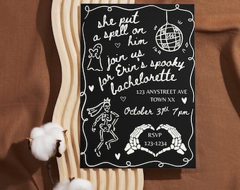 Pode incluir: Convite preto para despedida de solteira de Halloween com texto e ilustrações brancas. O convite inclui o texto "she put a spell on him" e "Erin's spooky bachelorette". O convite está em um fundo de madeira com algodão.
