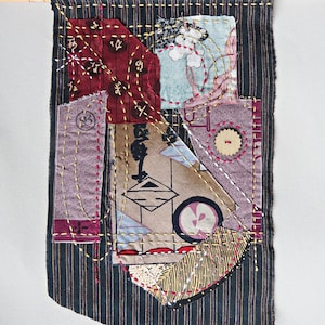 May include: A black and white striped fabric banner with a patchwork design. The banner is made of various fabrics in different colors and patterns, including red, pink, brown, and beige. The banner is stitched together with yellow thread.