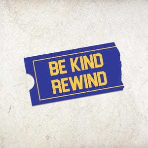 May include: A blue ticket stub with the words "BE KIND REWIND" in yellow, set against a textured, off-white background. The ticket has a rounded notch on the left side.