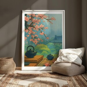 Pode incluir: Uma ilustração emoldurada de um jardim japonês com uma cerejeira em flor, uma casa tradicional e dois bules de chá em uma mesa de madeira. A cena se passa em um dia chuvoso com um céu azul suave.