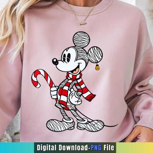May include: Pink sweatshirt featuring a cartoon Mickey Mouse design. Mickey is wearing a red and white striped scarf and holding a candy cane. The image includes the text "Digital Download-PNG File".