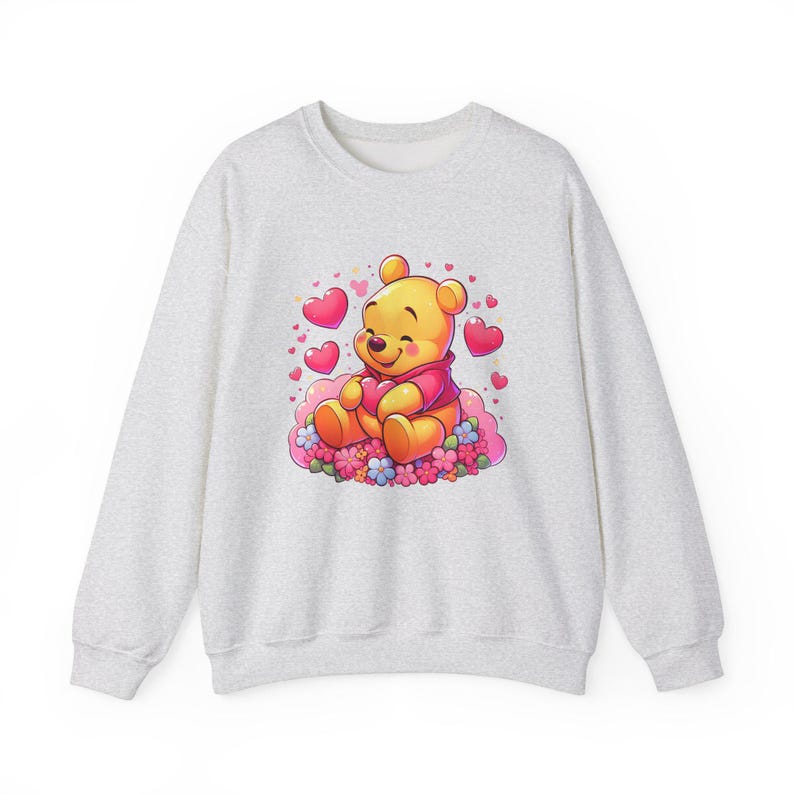 Puede incluir: Una sudadera gris con una imagen de dibujos animados de Winnie de Pooh sosteniendo un coraz&oacute;n rodeado de corazones rosas y flores.