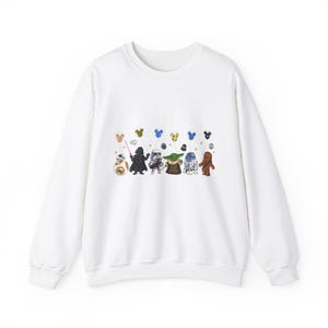 K&ouml;nnte beinhalten: Wei&szlig;er Pullover mit einem Aufdruck von Star Wars-Charakteren, die Mickey-Maus-Ballons halten. Zu den Charakteren geh&ouml;ren Darth Vader, R2-D2, Chewbacca und Yoda.
