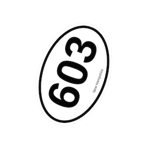 May include: Oval sticker with a black border, featuring the number "603" in bold black font. The text "New Hampshire" is printed in a smaller font along the bottom edge of the oval. The sticker is white.