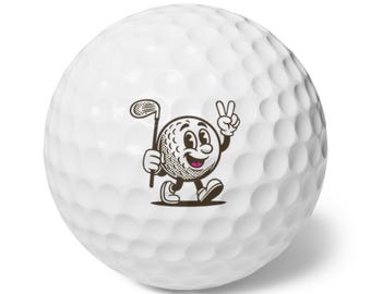 May include: White golf ball with a cartoon character design. The character is a golf ball with a face, holding a golf club and giving a peace sign. The golf ball has a dimpled surface.