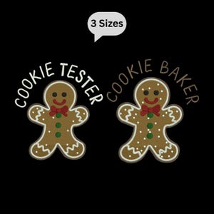 May include: Two gingerbread man designs on a black background. One says "Cookie Tester" and the other says "Cookie Baker". Both gingerbread men have a red bow tie, green buttons, and white icing details. A white speech bubble above says "3 Sizes".