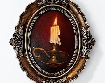 May include: An oval-shaped painting in an ornate, metallic bronze-colored frame. The artwork depicts a single lit candle with melting wax, set in a brass-colored candlestick holder against a dark, deep red background.