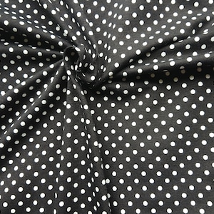 White polka dots on black jersey in organic cotton. Knitted fabric by half meter (50cm)